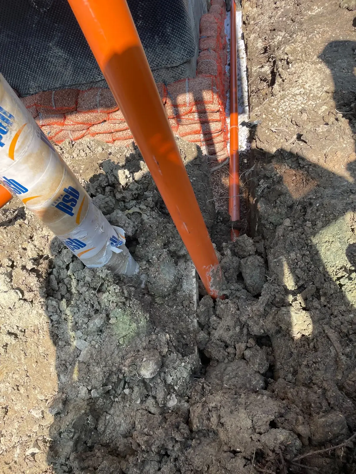 Worki z grysem ułożone wzdłuż fundamentów po naprawie drenażu