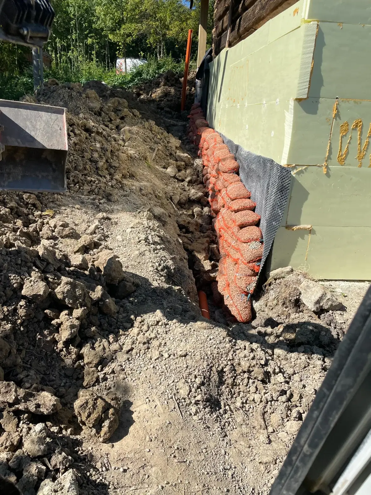 Rury drenażowe PVC ułożone ze spadkiem wokół fundamentów