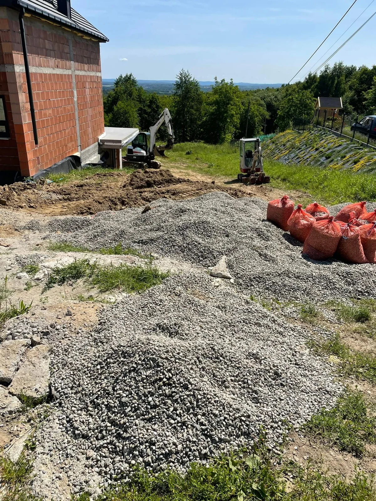 Teren przed wyrównaniem – działka z nierównościami i urobkiem przed rozpoczęciem prac ziemnych